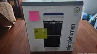 Closed box showing Simplehuman branding and image of the recycling bin drawer frame with bin inside.
