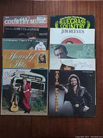 Photo showing 10 country music vinyl albums arranged in two rows, covers visible with artist names and titles.