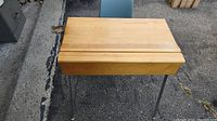 Wooden school desk with metal legs, top closed, viewed from above