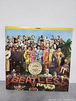 Front of Sgt. Pepper's Lonely Hearts Club Band album cover showing full artwork with large crowd and flowered Beatles text.