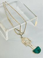 Silver twisted rope style chain and pendant placed on a white translucent stand to show details of chain and pendant close-up.