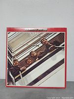 Front side of gatefold album cover showing The Beatles looking down from a balcony with red border and title 'The Beatles / 1962-1966'