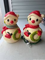 Two vintage Union Products blow mold snowmen side by side, showing their size and details with cords wrapped around their bodies and bulbs attached.