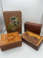 Four wooden boxes grouped together showing variety of decorative styles and sizes
