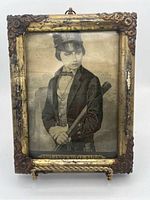 Frontal view of the antique silk picture in a decorative frame showing Prince Albert dressed as England's Royal Sailor, with visible wear and tear on both silk and frame.