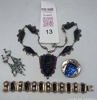 Full set of four vintage Mexican sterling silver jewelry pieces including necklace, brooch, bracelet, and earrings on white background.