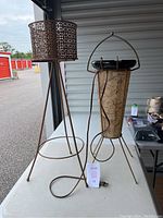Full view of mid century metal plant stand and light-up ashtray lamp side by side on a table