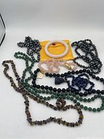 Overview of all 8 pieces including jade bangle, various bead necklaces in onyx, rose quartz, hematite, jade, lapis lazuli chips, and amethyst chip beads