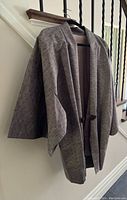 Full view of the grey men's haori jacket hanging on a hanger, showing the wide sleeves and overall cut.
