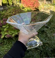 Heavy crystal pedestal bowl with octagonal sides held at an angle showing the bowl's shape and clarity.
