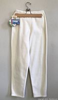 Cream fleece pants hanging on wooden hanger with Yukon EcoSpun fleece tag showing Canadian origin.