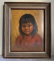 Front view of framed pastel portrait of Native child, showing the wood frame and the full artwork.