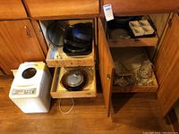 Breadmaker and glass baking dishes in wooden kitchen cabinet and drawers