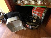 Full view of coffee maker box, slow cooker, canning pot, and two black roasting pans.