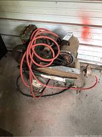 Overall front view of Sears air compressor showing belts, motor, compressor head, and orange air hose.