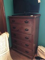 Full view of wood high boy dresser with six drawers and metal handles, showing overall shape and condition.