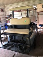 Rear three-quarter view of golf cart showing flip seat, roof, frame