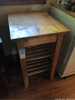 Front view of wooden food prep cart showing tabletop with scratches and lower slatted shelf