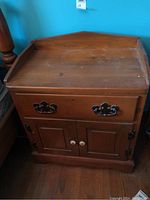 Main image showing one wooden night table with drawer and two-door cabinet, medium brown finish, visible surface wear.