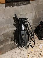 Full view of All Power electric pressure washer unit with cables coiled around the handle.