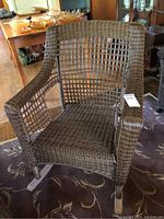 Full view of the brown wicker rocking chair showing its wooden rockers and overall design.