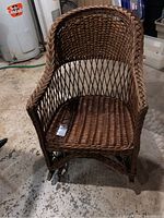 Front view of wicker rocking chair showing woven wicker seat, backrest and armrests