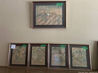 Five framed paintings displayed on shelf, one above four