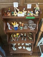 Front view of wooden decor shelf filled with various decorative figurines.