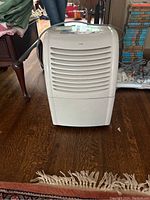 Front view of white Haier dehumidifier showing vent slats and top handle