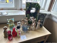 Overview of lot showing all 15 pieces: 7 glass cat figurines in front and 8 Demdaco Willow Tree-style figures and succulent frame in back