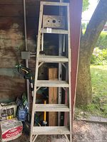 Front view of tall wooden step ladder showing painting step and handrail.