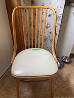 Single bentwood chair showing curved backrest with vertical slats and off-white vinyl seat cushion.