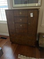Front view of dresser showing overall shape, wood veneer finish and brass-tone hardware