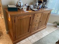 Front view of wooden sideboard cabinet with decorative items on top