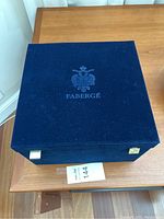 Closed blue Fabergé presentation case with embossed logo on lid.