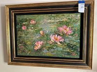 Full frontal view of framed oil painting showing pink water lilies on pond in gold-tone wood frame