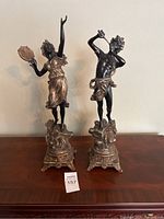 Frontal view of both bronze figurines on table