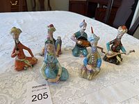 Front view of all six Persian figurines displayed on lace cloth