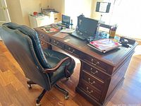 Full view of desk and matching leather chair positioned in home office, showing overall style and finish.