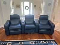 Front view of the three blue leather movie theater chairs arranged side by side, showing their connected design and overall condition.