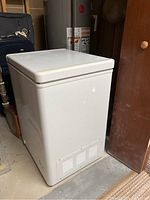 Full view of white chest freezer, showing compact size and lid closed.