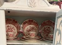 Front view showing two place settings including plates, salad plates, bread plates, teacups, and two wine glasses with pink flower decoration.