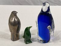 Photo showing all three penguin figurines together on a white background.
