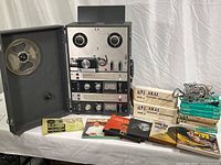 Full view of Akai M-8 deck in carrying case with loaded reel, two microphone boxes, manual, tapes and cables