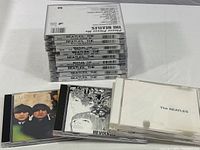 Stack of Beatles CDs with titles visible through clear cases, all with Tower Records tags mostly sealed.