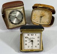All three travel alarm clocks displayed showing front faces and cases.