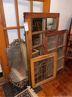 Group photo showing three framed mirrors together: largest wood-framed window mirror, bevelled oval mirror with ornate frame, and wood-framed leaded window mirror.
