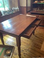 Full view of the rectangular pine table showing two open drawers and solid wood plank top with natural wood grain.