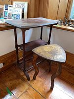 Full view of both side tables together showing their shapes, wood finish, and detailing
