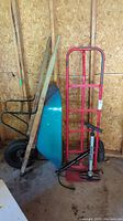 Wide view of the lot showing dolly cart, wheelbarrow, and bicycle tire pumps in garage setting